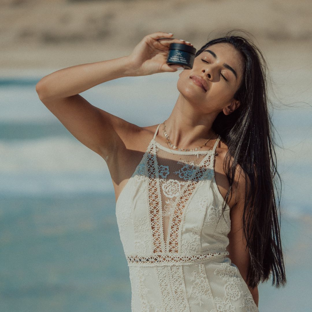 Woman holding The Dead Sea Co. Mineral Mask on the shores of the Dead Sea Jordan