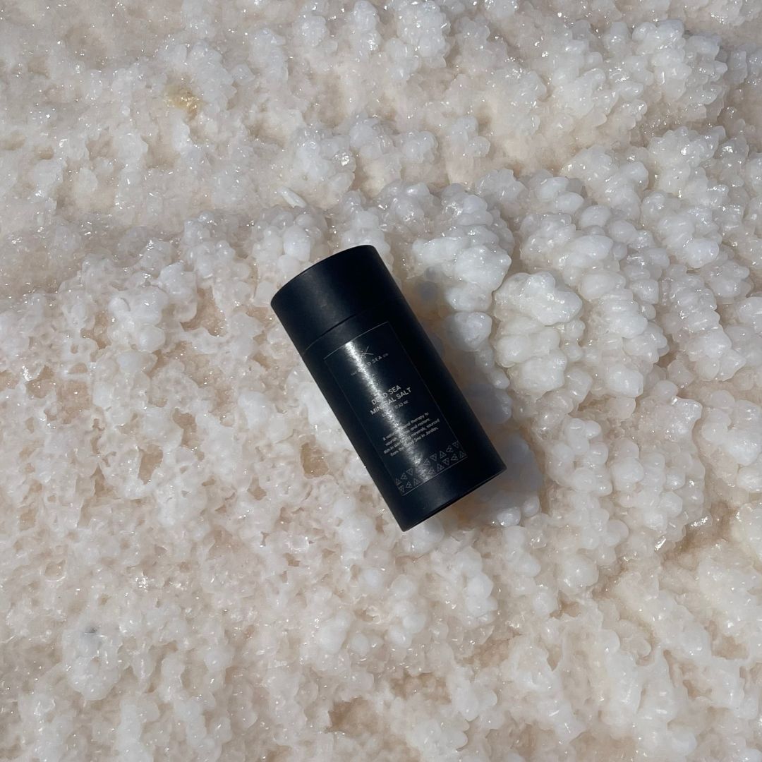 Dead Sea Mineral Salt by The Dead Sea Co. resting on natural salt crystals at the edge of the Dead Sea.