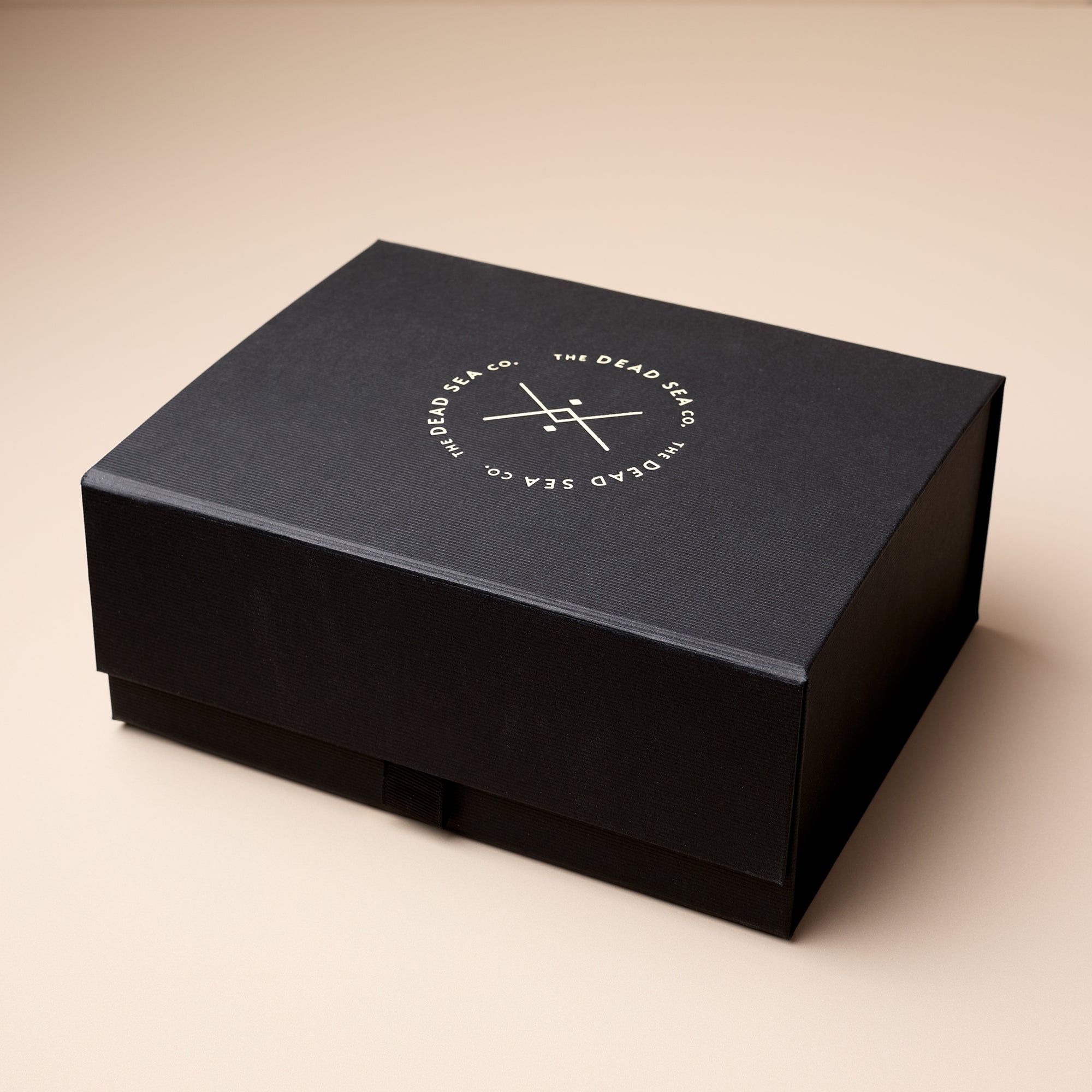 Luxury black skincare gift box from The Dead Sea Co., featuring minimalist gold-embossed logo—ideal for wellness and self-care gifting.