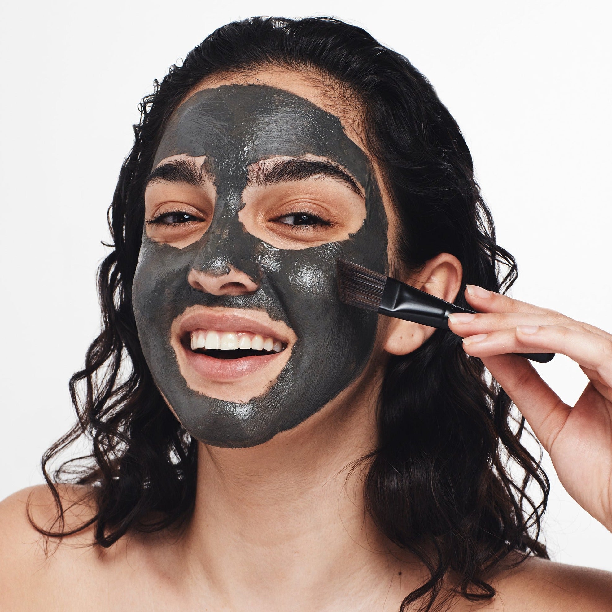 Pampering session: Woman indulging in a luxurious Dead Sea mud mask with The Dead Sea Co.'s precision brush.