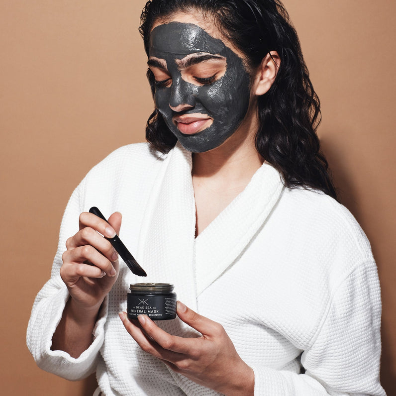 Self-care moment: Woman treating herself to a Dead Sea mud mask using The Dead Sea Co.'s angled brush for precise application.